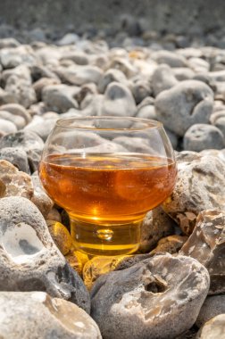 Etretat, Normandiya, Fransa 'nın çakıl taşları üzerinde elma şarabı ve gri taşlar.