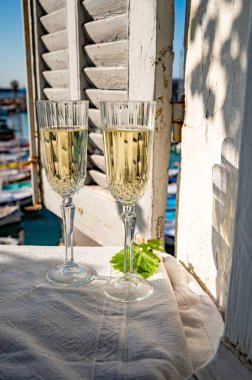 Yazın doğum günü kutlaması iki bardak Fransız şampanyası köpüklü şarap ve renkli balıkçı tekneleriyle Cassis, Provence, Fransa 'daki eski limanda.
