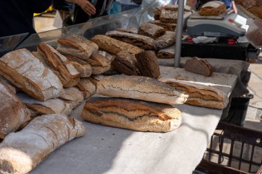 Doğal mayayla yapılan ekşi hamurlu biyolojik ekmek ve Provence, Fransa 'da pazarda satılmak üzere odun sobasında pişirildi.