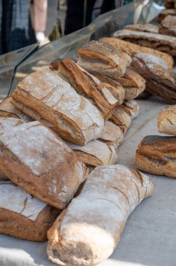 Doğal mayayla yapılan ekşi hamurlu biyolojik ekmek ve Provence, Fransa 'da pazarda satılmak üzere odun sobasında pişirildi.