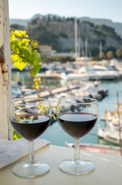 Açık terasta kırmızı şarap içmek yaşlı balıkçının limanını görmek Cassis, Provence, Fransa 'da renkli teknelerle