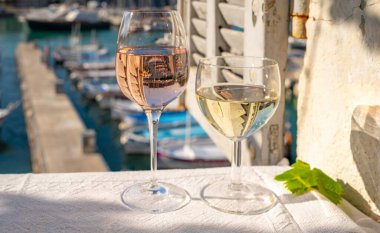 Cassis şarapları ve beyaz şarap üreten bölge, Cassis, Provence, Fransa 'daki renkli teknelerle eski balıkçıların limanı manzaralı terasta servis ediliyor.