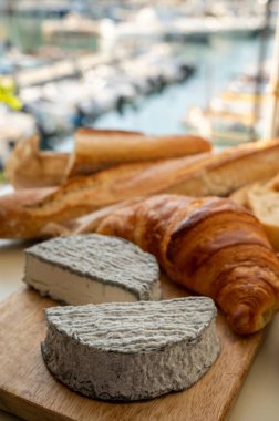 Fransız keçi peyniri selles-sur-cher ve taze kruvasan Cassis, Provence, Fransa 'nın limanındaki teknelerde servis ediliyor. Peynir tatma, yakın çekim.