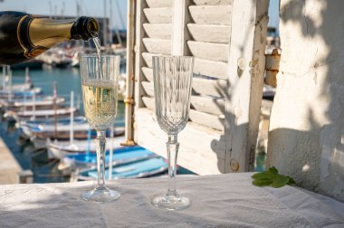 Yazın doğum günü kutlaması iki bardak Fransız şampanyası köpüklü şarap ve renkli balıkçı tekneleriyle Cassis, Provence, Fransa 'daki eski limanda.