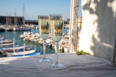 Yazın doğum günü kutlaması iki bardak Fransız şampanyası köpüklü şarap ve renkli balıkçı tekneleriyle Cassis, Provence, Fransa 'daki eski limanda.