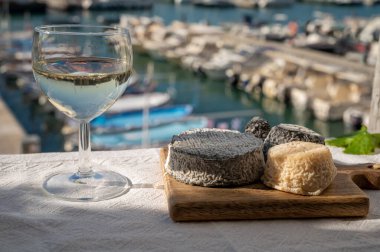 Fransız keçi peyniri crottin ve selles-sur-cher Cassis, Provence, Fransa 'nın limanındaki teknelerde sunuldu. Peynir, bir bardak kuru beyaz şarapla tattı.