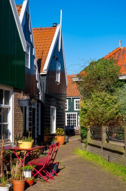 Hollanda 'nın küçük Marken kasabasında güneşli bir bahar gününde eski Hollanda, Hollanda' da bulunan ahşap evlerle yürüyorum.