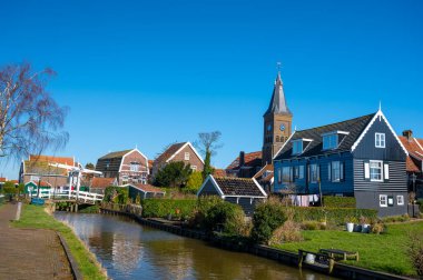 Hollanda 'nın küçük Marken kasabasında güneşli bir bahar gününde eski Hollanda, Hollanda' da bulunan ahşap evlerle yürüyorum.