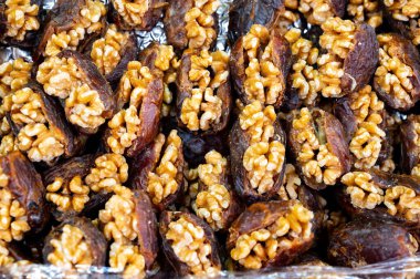 Turkish or arabic sweet dessert, ripe dried dadels with walnuts sweetened with syrup or honey, close up