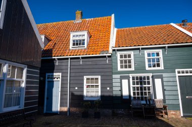 Hollanda 'nın küçük Marken kasabasında güneşli bir bahar gününde eski Hollanda, Hollanda' da bulunan ahşap evlerle yürüyorum.