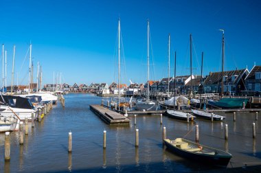 Hollanda 'nın küçük Marken kasabasında güneşli bir bahar gününde eski Hollanda, Hollanda' da bulunan ahşap evlerle yürüyorum.