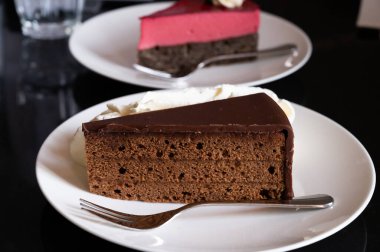 Kayısı reçelli Sachertorte çikolatalı pastası ve Avusturya menşeli ahududu kremalı haşhaşlı kek. Viyana 'daki eski klasik kafe restoranında kremayla servis ediliyor.