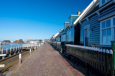 Hollanda 'nın küçük Marken kasabasında güneşli bir bahar gününde eski Hollanda, Hollanda' da bulunan ahşap evlerle yürüyorum.