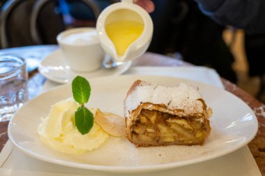 Avusturya tatlısı, krem şantili elmalı turta ve sıcak vanilyalı sos Viyana, Avusturya 'daki eski fırın kafede servis ediliyor.