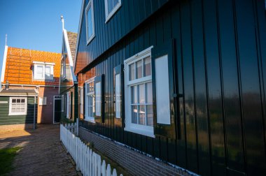 Hollanda 'nın küçük Marken kasabasında güneşli bir bahar gününde eski Hollanda, Hollanda' da bulunan ahşap evlerle yürüyorum.