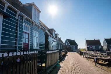 Hollanda 'nın küçük Marken kasabasında güneşli bir bahar gününde eski Hollanda, Hollanda' da bulunan ahşap evlerle yürüyorum.