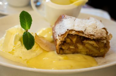 Avusturya tatlısı, krem şantili elmalı turta ve sıcak vanilyalı sos Viyana, Avusturya 'daki eski fırın kafede servis ediliyor.