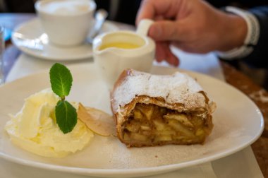 Avusturya tatlısı, krem şantili elmalı turta ve sıcak vanilyalı sos Viyana, Avusturya 'daki eski fırın kafede servis ediliyor.