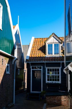 Hollanda 'nın küçük Marken kasabasında güneşli bir bahar gününde eski Hollanda, Hollanda' da bulunan ahşap evlerle yürüyorum.