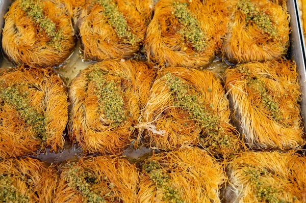 Turkish or arabic sweet dessert, baklava burma kadayif made from filo pastry, filled with chopped pistachio nuts and sweetened with syrup or honey, close up