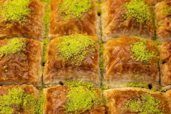 Turkish or arabic sweet dessert, baklava fistikli made from filo pastry, filled with chopped pistachio nuts and sweetened with syrup or honey, close up