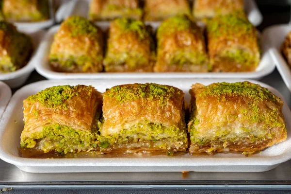 Turkish or arabic sweet dessert, baklava made from filo pastry, filled with chopped pistachio nuts and sweetened with syrup or honey, close up