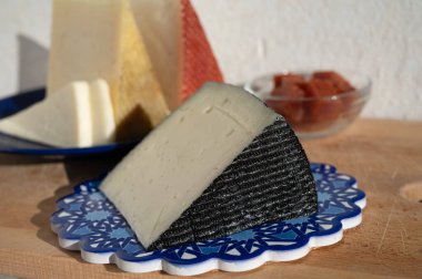 İspanyol sert manchegosu, inek, koyun ve keçi peyniri açık havada, mavi Endülüs stili tahtasında güneş ışığında membrillo reçeli servis edilir.