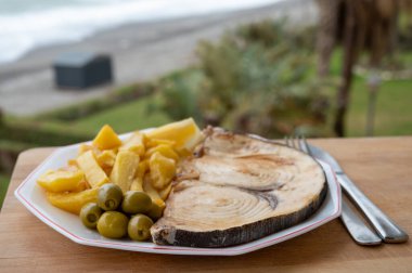 Deniz ürünleri tabağı deniz manzaralı, kıIıçbalığından ızgara biftek ya da patates kızartması ve yeşil zeytinle servis edilen spada, yakın çekim.