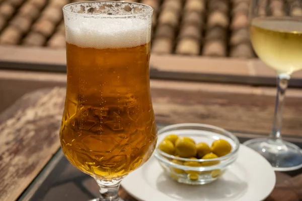 Spanish beer, wine and glass bowl with green andalusian olives served on outdoor terrace in Granada, Andalusia, Spain