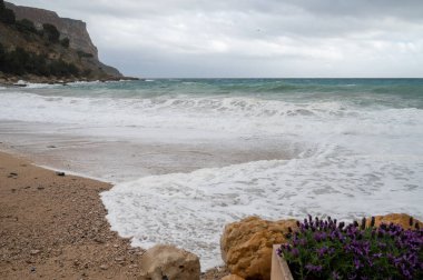 Denizde fırtına, Cassis, Provence, Fransa 'daki sarı kumlu sahilde yüksek dalgalar.
