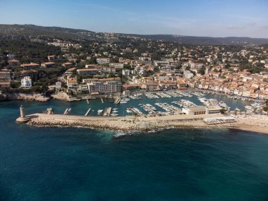 Kumsalda panoramik hava manzarası, mavi deniz, uçurumlar, evler, sokaklar ve Cassis, Provence, Fransa 'da deniz feneri olan eski balıkçıların limanı bulutlu bir günde
