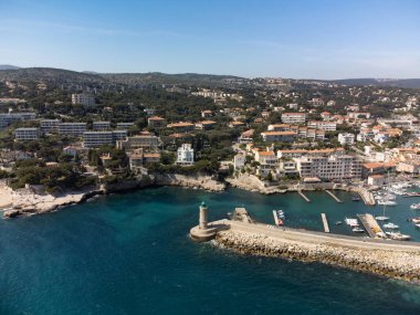 Kumsalda panoramik hava manzarası, mavi deniz, uçurumlar, evler, sokaklar ve Cassis, Provence, Fransa 'da deniz feneri olan eski balıkçıların limanı bulutlu bir günde