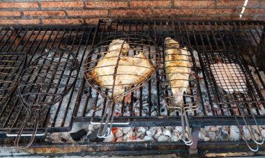Eski mangal kömürü parillas beyaz balık levrek ve turbot, küçük balıkçı köyü Getaria, Bask Ülkesi, İspanya 'daki binaların dışına inşa