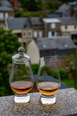 Arka plandaki eski evleri gören iki bardak viski, Edinburgh viski tatma turu, İskoçya
