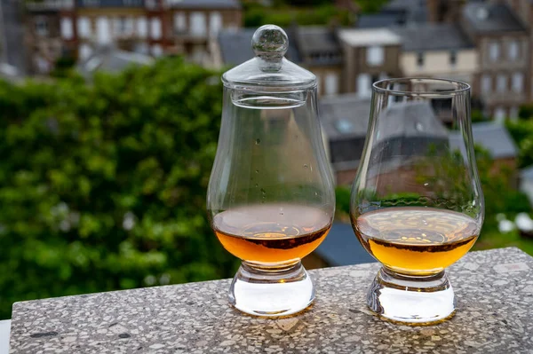 Two drams of scotch whiskey with view on old houses on background, Edinburgh whisky tasting tour, Scotland