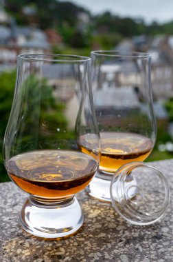 Arka plandaki eski evleri gören iki bardak viski, Edinburgh viski tatma turu, İskoçya