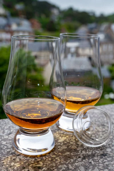 Two drams of scotch whiskey with view on old houses on background, Edinburgh whisky tasting tour, Scotland