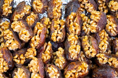 Turkish or arabic sweet dessert, ripe dried dadels with walnuts sweetened with syrup or honey, close up