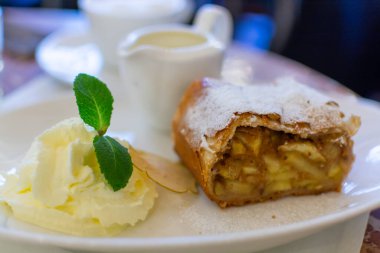 Avusturya tatlısı, krem şantili elmalı turta ve sıcak vanilyalı sos Viyana, Avusturya 'daki eski fırın kafede servis ediliyor.
