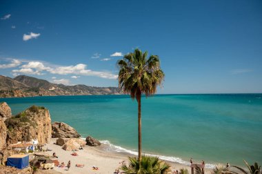 Seyahat güzergahı, mavi deniz manzarası ve küçük Endülüs kasabası Nerja 'daki Balcon de Europa' dan ilkbaharda İspanya 'nın Costa del Sol kentinde dar sokakları ve beyaz evleri olan dağlar.