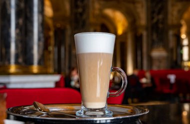 Viyana 'da kırmızı sandalyeli eski Avusturya kafe restoranında servis edilen bir bardak kahve.