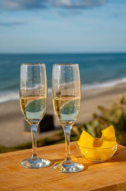 Güneşli bir günde İspanyol Cava şarabı, ananas ve mavi deniz manzaralı açık hava kahvaltısı ve Marbella 'da kumlu plaj, Costa del Sol tatil beldesi, Endülüs, İspanya