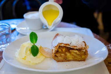 Avusturya tatlısı, krem şantili elmalı turta ve sıcak vanilyalı sos Viyana, Avusturya 'daki eski fırın kafede servis ediliyor.