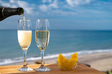 Güneşli bir günde İspanyol Cava şarabı, ananas ve mavi deniz manzaralı açık hava kahvaltısı ve Marbella 'da kumlu plaj, Costa del Sol tatil beldesi, Endülüs, İspanya