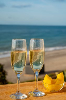 Güneşli bir günde İspanyol Cava şarabı, ananas ve mavi deniz manzaralı açık hava kahvaltısı ve Marbella 'da kumlu plaj, Costa del Sol tatil beldesi, Endülüs, İspanya