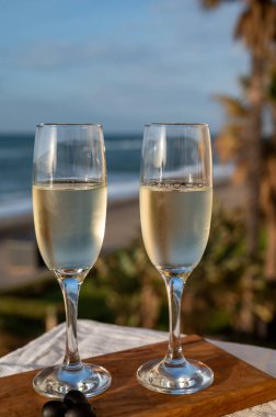 İspanyol bardakları köpüklü şarap ve mavi deniz manzaralı kumlu sahil, Costa del Sol yaz tatili merkezi, Endülüs, İspanya