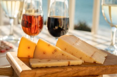 Pedro Ximenez tatlı şeri ile doldurulmuş İspanyol sert Endülüs peyniri arka planda mavi deniz bulunan iki bardak şeri şarabı ile servis edilir.