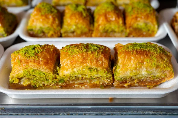 Turkish or arabic sweet dessert, baklava made from filo pastry, filled with chopped pistachio nuts and sweetened with syrup or honey, close up