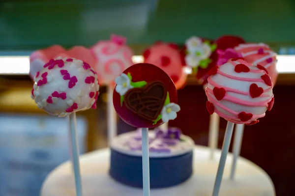 Food styling in bakery, wedding or happy valentine colorful lollypop candies decorated with chocolate hearts and flowers