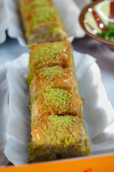 Turkish or arabic sweet dessert, baklava made from filo pastry, filled with chopped pistachio nuts and sweetened with syrup or honey, close up